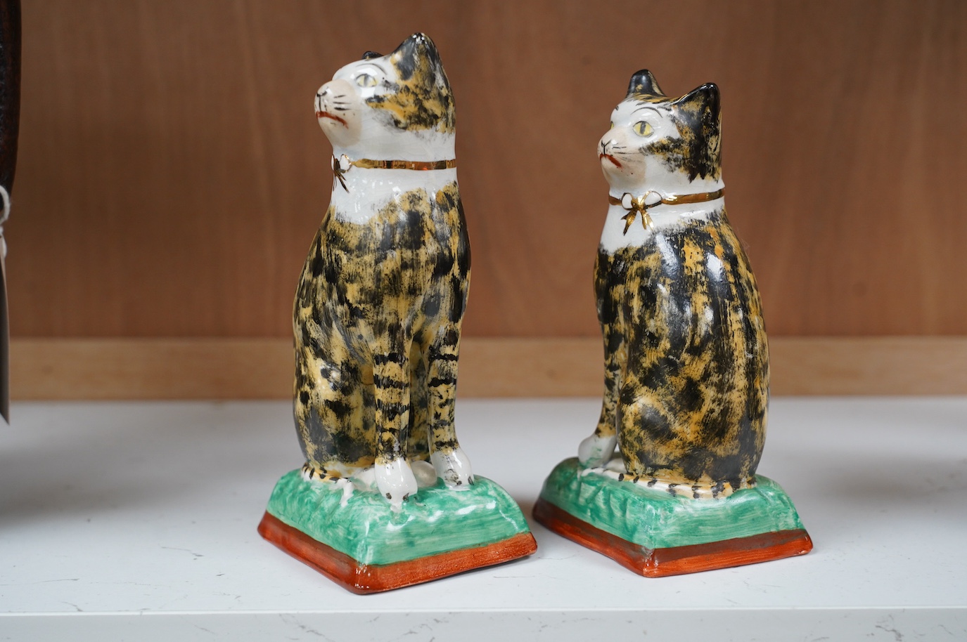 A pair of early 20th century Staffordshire cats, 17cm. Condition - good, some crazing